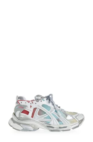 A single athletic sneaker featuring a multicolor mesh and synthetic upper in red, blue, white, and beige tones, with a gray sole and white laces, positioned on a plain white background.