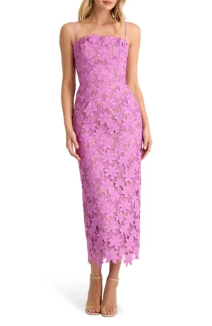 A woman wears a sleeveless, pink lace midi dress with thin straps and floral detailing, resembling the Helsi Leslie Strapless Sequin Lace Column Midi Dress. The fitted bodice and scalloped hem pair perfectly with nude, open-toe heels.