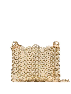A small gold handbag with a scalloped edge, intricate cut-out pattern, and a gold chain shoulder strap, inspired by the Rabanne Flower Printed Steel Pailette Shoulder Bag, displayed against a plain white background.