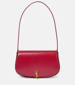 A red Voltaire Shoulder Bag with a curved flap, single strap, and gold-toned YSL logo on the front, displayed against a plain white background.