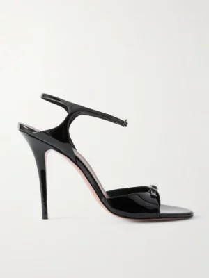 A black patent leather high-heeled sandal with a thin ankle strap and open toe, inspired by the Amina Muaddi Adut Crystal-embellished Buckled Patent-leather Sandals, displayed in profile against a plain white background.