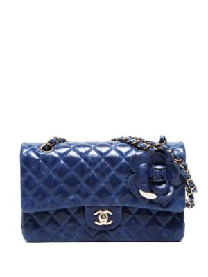 A blue quilted leather Chanel Pre-Owned 2018 Medium Classic Lambskin Double Flap Shoulder Bag featuring a gold-tone chain strap, gold CC logo clasp, and a decorative leather flower charm attached to the strap.