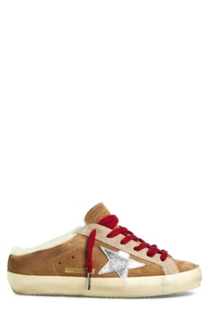 A brown suede low-top sneaker inspired by Golden Goose Hi Star Distressed Leather Sneakers, featuring a white rubber sole, red laces, silver star emblem on the side, beige accents, and fuzzy white lining around the opening.