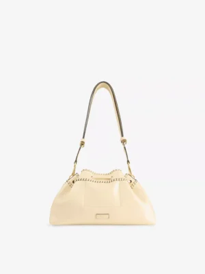 A cream-colored shoulder bag in snakeskin-embossed leather with gold hardware, a curved top handle, decorative stitching along the top edge, and a front pocket detail, set against a plain white background.