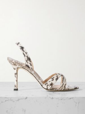 A high-heeled sandal inspired by Manolo Blahnik Chaos 90 Satin Sandals, with a snakeskin pattern, slender heel, open toe, and thin slingback strap, displayed on a white marble surface against a neutral background.