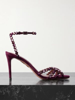 A single high-heeled sandal in dark purple velvet with a thin ankle strap and crisscrossing straps adorned with round purple gemstones, inspired by the elegance of Aquazzura Lumiere 105 Metallic Crystal-Embellished Cutout PVC Pumps.