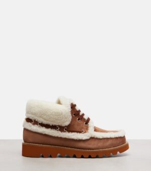 A brown suede Desert Boot with white shearling trim and lining, brown laces, and a thick brown ridged rubber sole, displayed in profile on a neutral surface against a plain background, perfect for strolls down Palm Avenue.
