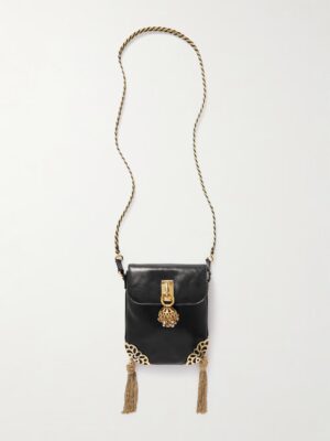 A black rectangular Chloé Château Treasures Embellished Textured-leather Shoulder Bag with a long twisted gold strap, gold tassels at the bottom corners, filigree accents, and a gold clasp with an ornate decorative charm on the front flap.