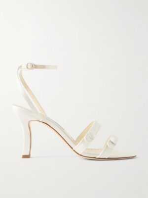 A white Manolo Blahnik Neusita 90 Satin Sandal with an ankle strap and buckle, two thin toe straps, and a lightly padded insole, shown in side profile against a plain background.