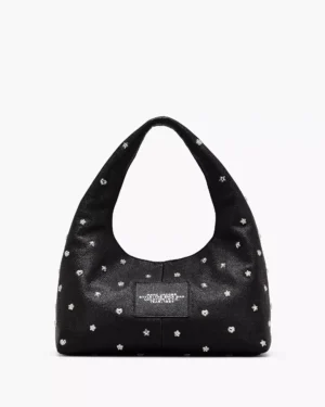 A black leather Marc Jacobs The Sequin Charm Shoulder Bag with a thick, rounded strap. The bag features small silver floral and heart-shaped studs and a rectangular label patch on the front. Background is plain white.