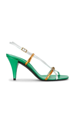 A high-heeled Versace Opera Embellished Patent-leather Slingback Sandal featuring a green sole and heel, silver and gold metallic straps, and a small decorative element on the front strap. The mid-height heel has a glossy finish.